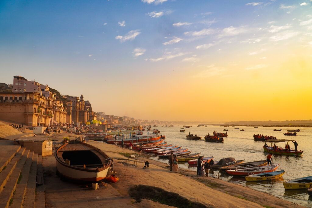 Stunning view of Varanasi's ghats during golden hour with boats on the Ganges River.